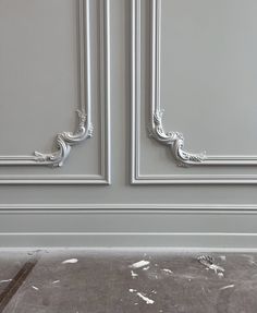 an empty room with gray walls and white trimmings on the door, which is peeling