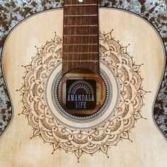 an acoustic guitar with the words anandala life on it's fret