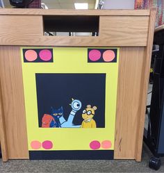 a cardboard box with cartoon characters painted on the front and sides, sitting in a room