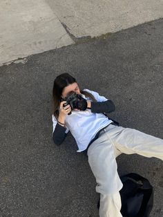 a woman laying on the ground with a camera