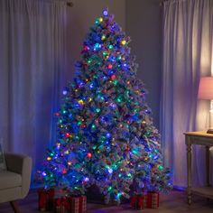 a brightly lit christmas tree in a living room