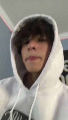 a person wearing a white hoodie and holding a cell phone