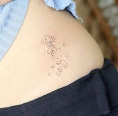 the back of a woman's stomach with a small tattoo on her left side