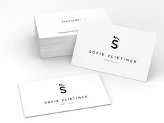 three white business cards with black and white logos are stacked on top of each other