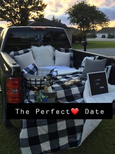 the back of a pick up truck with pillows and blankets in the bed is shown