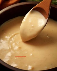 a wooden spoon is being used to dip sauce