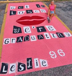 a woman sitting on top of a pink rug with words written in black and white