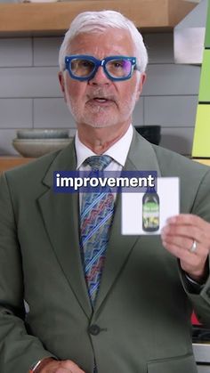 an older man wearing glasses holding up a business card with the words improvement on it