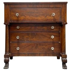 an antique chest of drawers with brass pulls and knobs on the front, against a white background