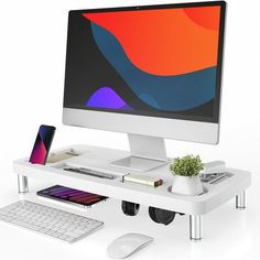 a computer monitor sitting on top of a white desk next to a keyboard and mouse