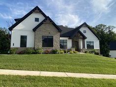 a large house sitting in the middle of a lush green field on a sunny day