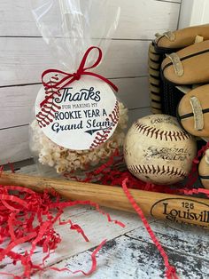 a baseball bat, ball and some candy on a table with red streamers around it