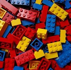 a pile of legos that are all red, yellow and blue with some black on them