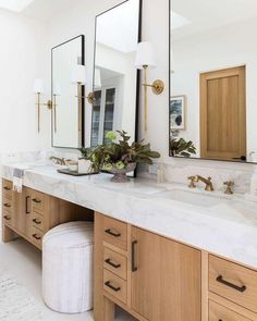 a bathroom with two sinks and mirrors on the wall