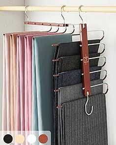 a rack with pants hanging on it next to a wall