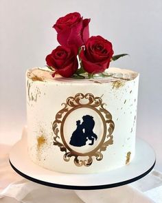 a white cake with red roses on top