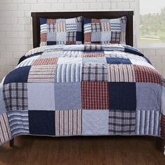 a bed with a blue and red quilt on it