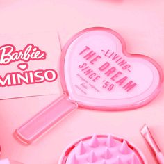 a pink heart shaped box with the words barbie miniso on it next to other items