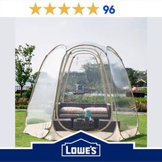 a couch sitting inside of a tent on top of a green grass covered field with five stars above it