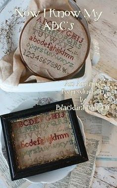 two cross - stitch samples in a box with the words now i know my abcu