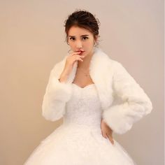 a woman in a white dress and fur coat