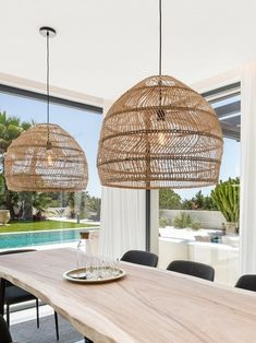 the dining room table is made out of wood and has two hanging lights above it