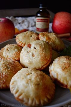 several pastries on a plate with apples and cinnamon in the background