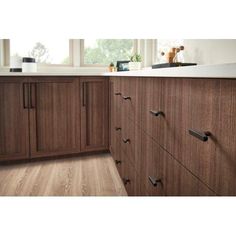 a kitchen with wooden cabinets and white counter tops