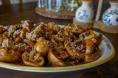 mushrooms covered in sesame seeds sit on a plate