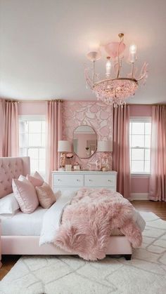 a bedroom decorated in pink and white with a chandelier