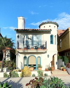 a large white house with blue trim and balconies on the second story balcony