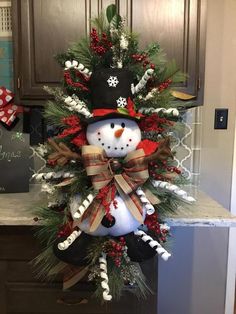 a snowman wreath on top of a kitchen counter