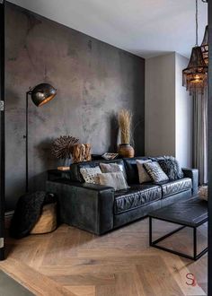 the living room is decorated in black and grey tones with wood flooring, chandelier