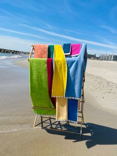 towels are drying on a clothes rack at the beach