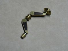 two brass handles on a white surface