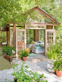 an image of a small garden shed with lots of plants and flowers in the yard