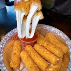 someone is dipping sauce on some fried food