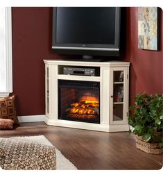 a living room with a fireplace and television on the stand in front of red walls