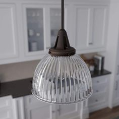 a glass light hanging from a ceiling in a kitchen