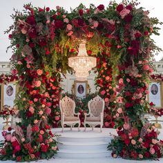 an outdoor ceremony with flowers and chandelier