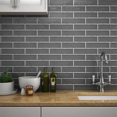 a kitchen with grey tiles and wooden counter tops