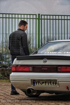 a man standing next to a parked car