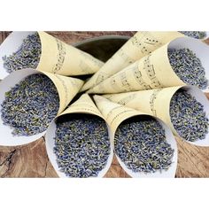 four white bowls filled with lavender sprinkles on top of a wooden table