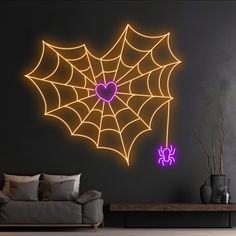 a living room with a couch, table and spider web wall decal on the wall