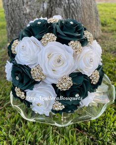 the bridal bouquet is made with white and green flowers, brooches and pearls