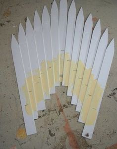 several white surfboards are laying on the ground with yellow paint all over them,