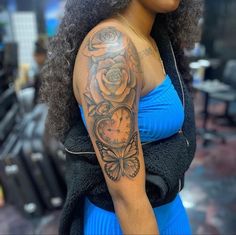 a woman with a clock and roses tattoo on her arm is looking at the camera