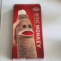 a hand holding a wine bottle wrapped in a knitted sock with the words wine monkey on it