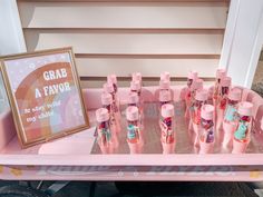 a pink cart filled with lots of different types of hair products and a framed sign