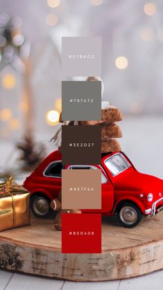 a red toy car sitting on top of a wooden table next to a christmas tree